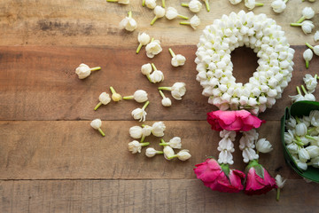 Thai traditional jasmine garland On wooden background symbol of Mother's day in thailand, to offer the monk or buddha.