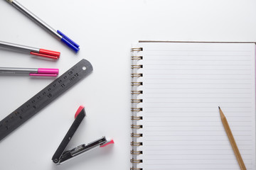 notebook pencil ruler and stapler on white background