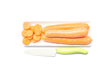 Closeup pile of cut carrot and fresh carrot on ceramic square plate with knife isolated on white background , prepare for cook concept with clipping path