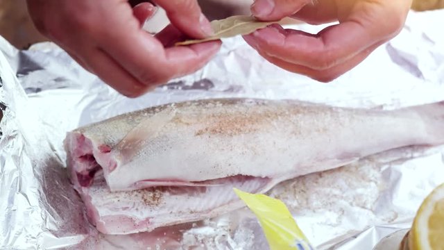 Process of cooking fish with lemon and herbs hands cook on a cutting board and wrap in foil. 3840x2160