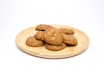 Chocolate chip and nut cookies on wooden plate isolated on white background.