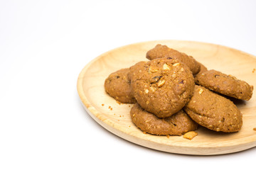 Chocolate chip and nut cookies on wooden plate isolated on white background.