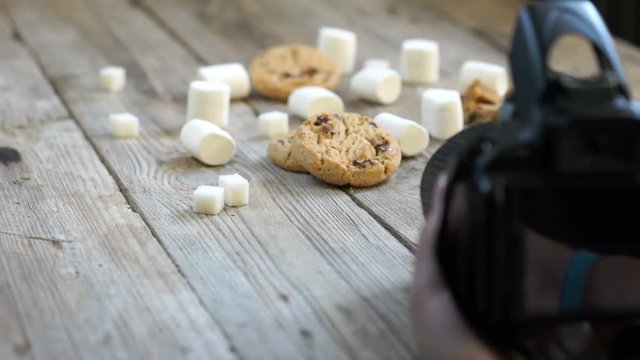 Marshmallows and cookies on a wooden background.