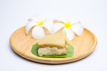Thai Dessert, sticky rice and egg custard creamy wrapped banana leaf, on a wooden plate,
