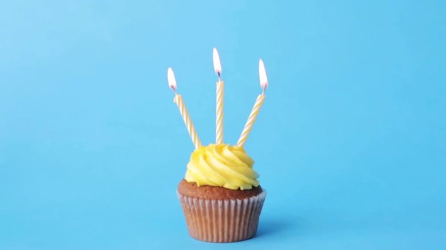 birthday cupcake with three burning candles