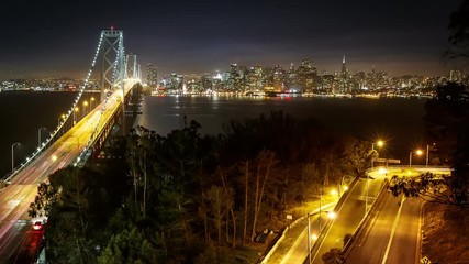 Time Lapse of traffic driving across the Bay Bridge in San Francisco. The buildings of San Francisco can be seen in the distance. Time Lapse.
