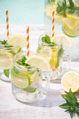 Lemonade drink in the jug on the white table near the pool