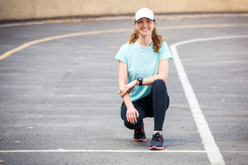 Portrait of cheerful young woman ready to start running session.