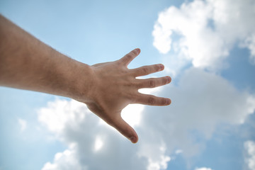 hand touching the blue sky