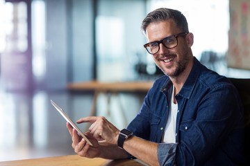 Portrait of smiling man using digital tablet