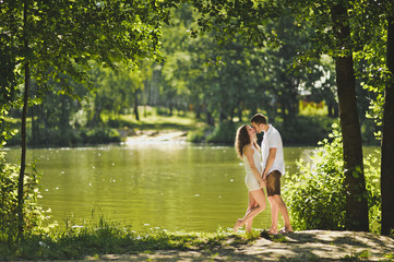 Young boy and girl standing on the shore of green lake 6303.