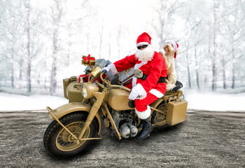 Nikolaus auf Motorrad Oldtimer mit Hund auf Strasse vor verschneitem Hintergrund