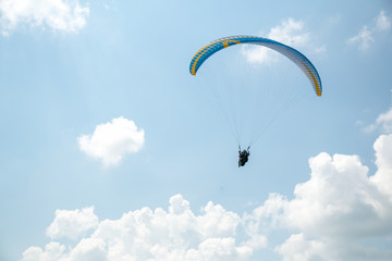 Paraglider in the blue sky, big blue clouds