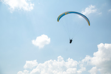 Paraglider in the blue sky, big blue clouds