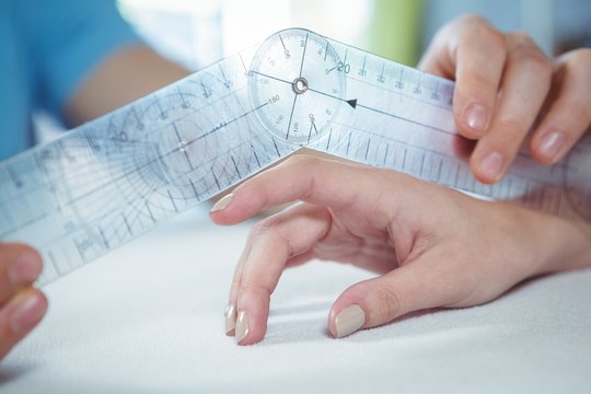 Physiotherapist examining female patient's finger