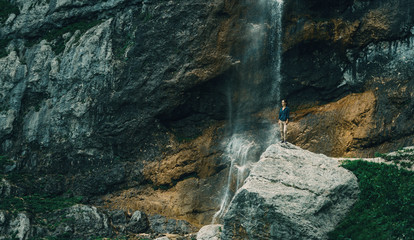 Traveler standing near the waterfall