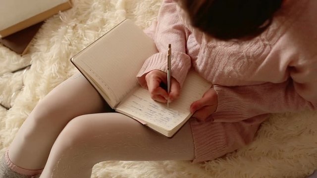 Beautiful woman writing in her diary
