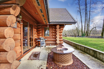 Large log cabin house exterior with patio area. - obrazy, fototapety, plakaty