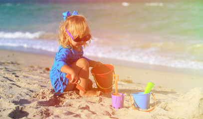 cute little girl play with sand on beach