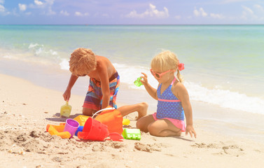 kids play with sand on summer beach