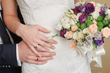 hands bride and groom with rings on waist
