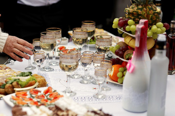 The buffet table with snacks and alcohol are near house