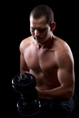 athlete with a dumbbell isolated on a black background