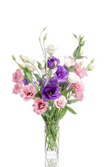 bunch of violet, white and pink eustoma flowers in glass vase is