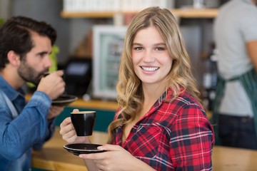 Portrait of happy woman having cup of coffee in cafe