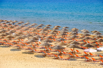 Beach umbrella and sunbeds on the sandy beach in Greece