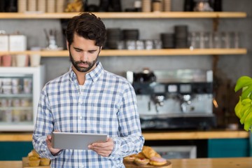Man using digital tablet at cafe