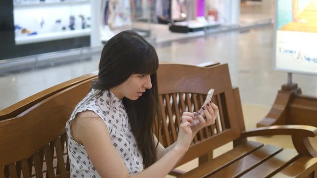Young woman indoor at shopping center, using smart phone