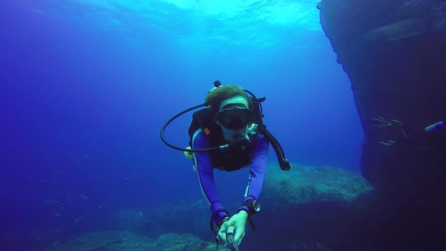 Underwater scuba diving selfie shot with selfie stick. Deep blue sea. 