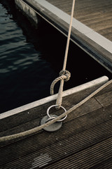 Nautical rope tied to a ring on a jetty.