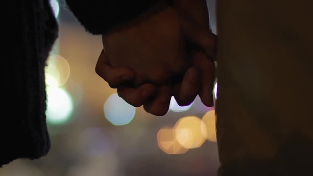 Girl and boy standing close with interlocked fingers, first date, true love