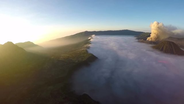 Aerial view flight over Cemoro Lawang, small village in morning mist. Which situated on the edge of massive north-east of Mount Bromo, East Java, Indonesia
