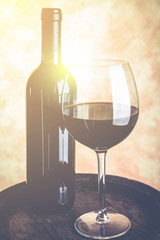red wine glass with bottle and barrel