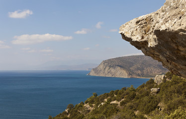 Rocks and mountains,covered with forest,over the sea.