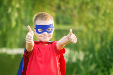  Kid in superhero costume showing thumbs up. T