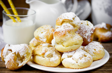 Cream puffs filled vanilla custard and sugar powder icing traditional French cuisine selective focus
