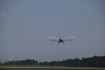 Fototapeta na wymiar The spraying of fertilizers and pesticides on the field with the aircraft.