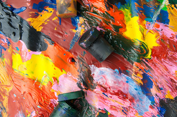 Boxes and oil paints multicolored closeup abstract background from above