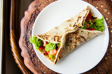 Big pita on the plate with fresh vegetables