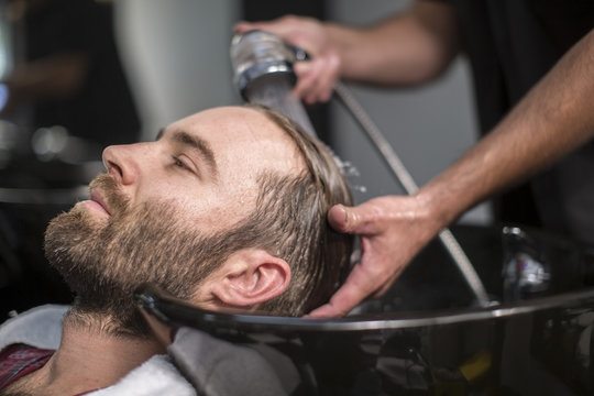 Barber washing customer hair
