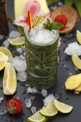 Tropical cocktails served in a tiki style glass and garnished with fruits and ice