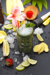 Tropical cocktails served in a tiki style glass and garnished with fruits and ice