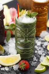 Tropical cocktails served in a tiki style glass and garnished with fruits and ice