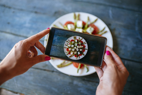 Hands of woman taking picture of food ready to eat, close-up