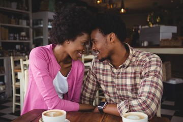 Young couple romancing while having coffee