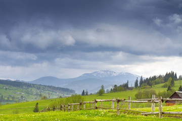 Carpathian mountain valley with road and fence